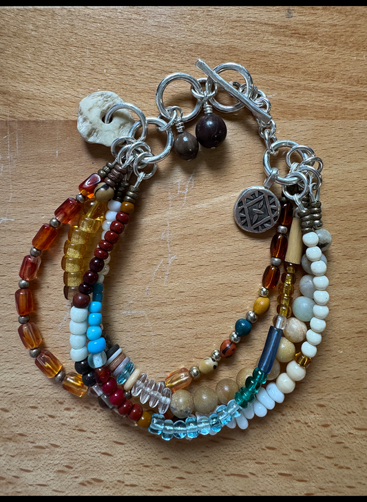 Multicolored beaded bracelet with charms on a wooden surface