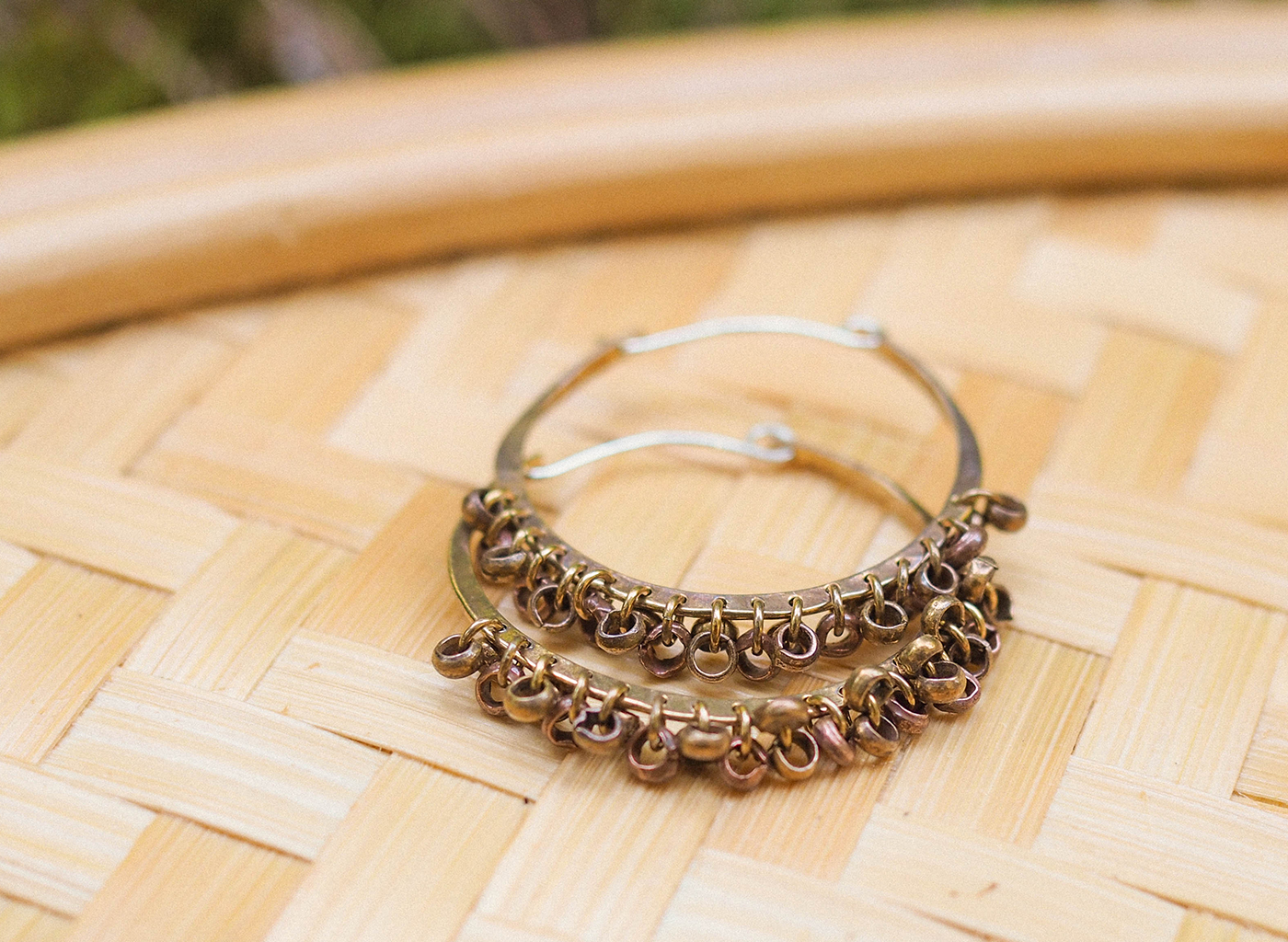 Pair of gold hoop earrings on a woven surface